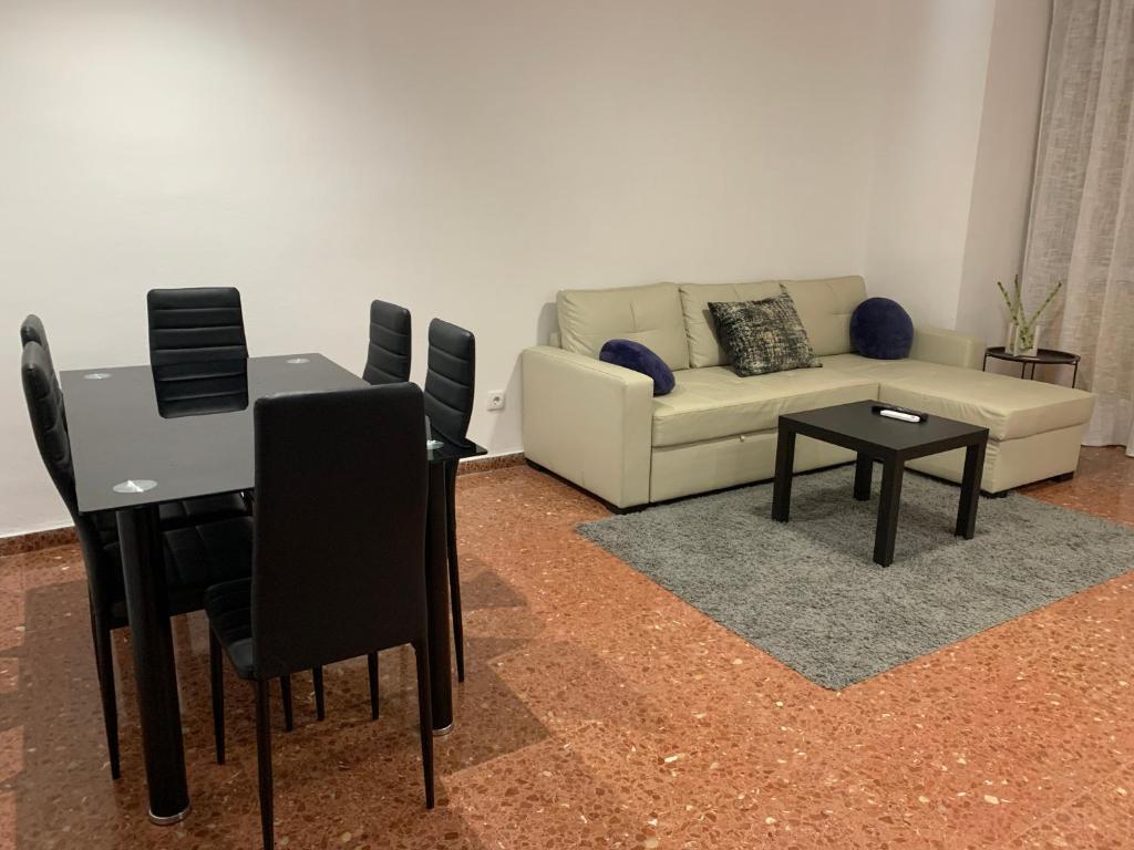 een woonkamer met een bank en een tafel bij Room Valdeolleros in Córdoba
