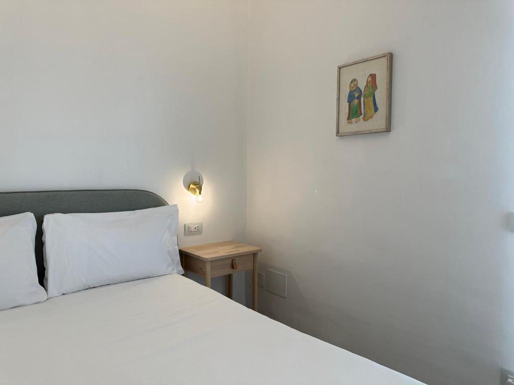 a bedroom with a bed and a picture on the wall at NG Guest House l'Acquedotto in Olbia