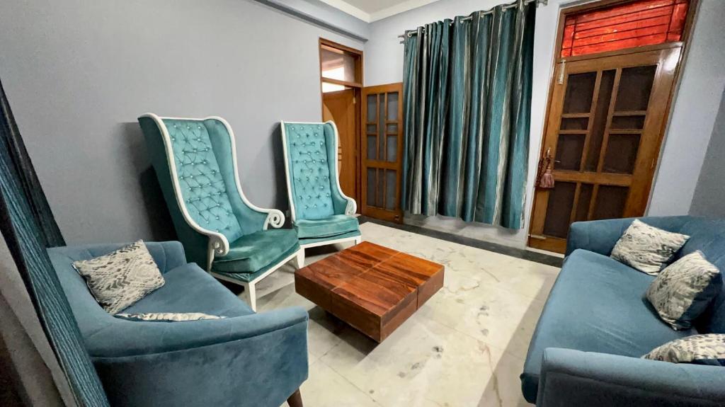 sala de estar con sillas azules y mesa de centro en Entire floor 2BHK with full Kitchen Near Medanta hospital, en Gurgaon