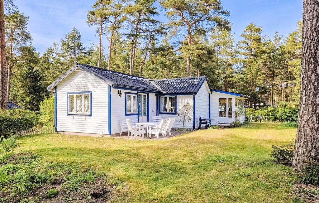 a white cottage with a table and chairs in a yard at 1 Bedroom Stunning Home In hus in Åhus