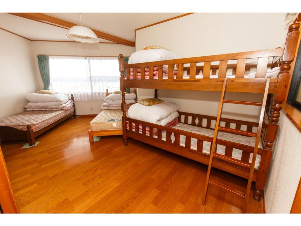 a room with three bunk beds in it at Lake Kawaguchi Rental Villa Tozawa Center - Vacation STAY 46680v in Oishi
