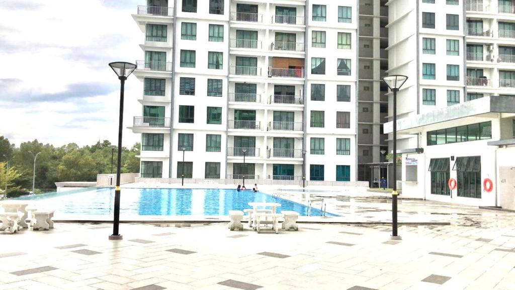 a swimming pool in front of a tall building at Allure - Casa Kayangan Meru Ipoh by GOSWELL in Ipoh