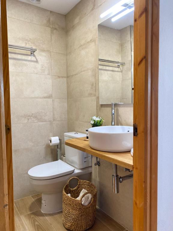 a bathroom with a sink and a toilet and a mirror at Apartamento Sa Farola in Cala en Blanes