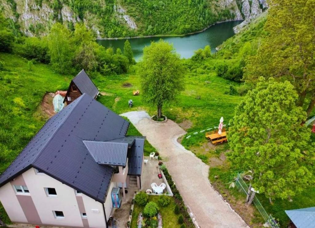 une maison au milieu d'un champ avec un lac dans l'établissement Biserna Dolina Uvac, à Sjenica