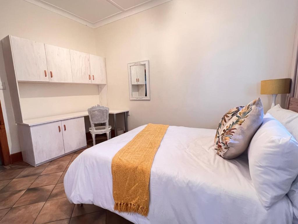a bedroom with a bed and a desk and a chair at Peaceful@Swansea In Rosebank-Parkwood in Johannesburg
