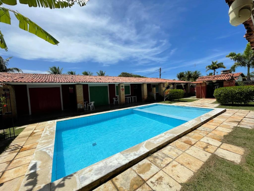 a swimming pool in front of a house at Casa Saberé - 100m da Praia - 2 Suítes - 4 adultos in Porto De Galinhas