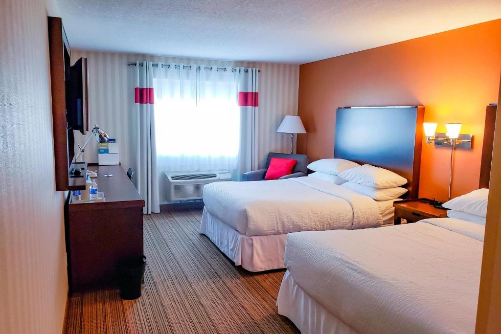 a hotel room with two beds and a window at Prestige Prince George Lodge in Prince George