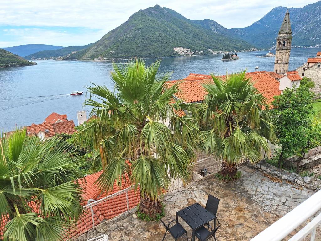 a view of a town with palm trees and a clock tower at Forteca home in Perast