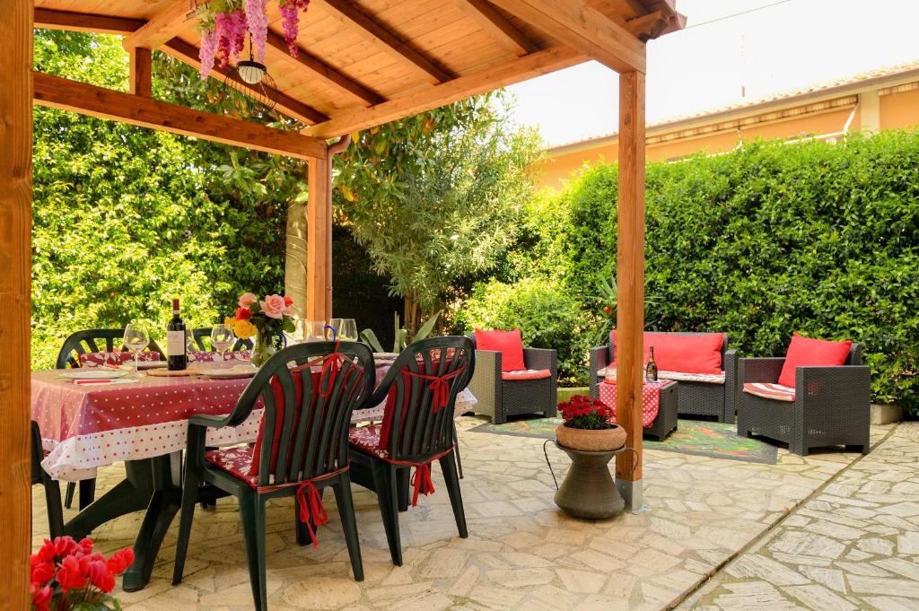 une terrasse avec une table et des chaises sous une pergola en bois dans l'établissement Alloggio turistico Giuly ID 3807, à Monte Porzio Catone