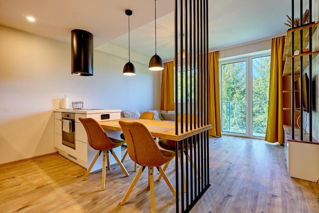 eine Küche und ein Esszimmer mit einem Holztisch und Stühlen in der Unterkunft Klínovec Suite in Loučná pod Klínovcem
