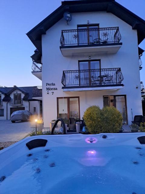 a building with a large pool in front of a house at Willa Perła Morza in Władysławowo