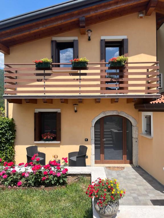 ein Haus mit einem Balkon mit Blumen im Hof in der Unterkunft Casa Conchet in Polcenigo