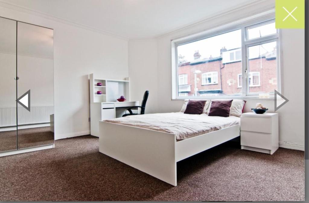 a white bedroom with a bed and a window at Budget Double Room Close to Leeds University and City centre in Leeds