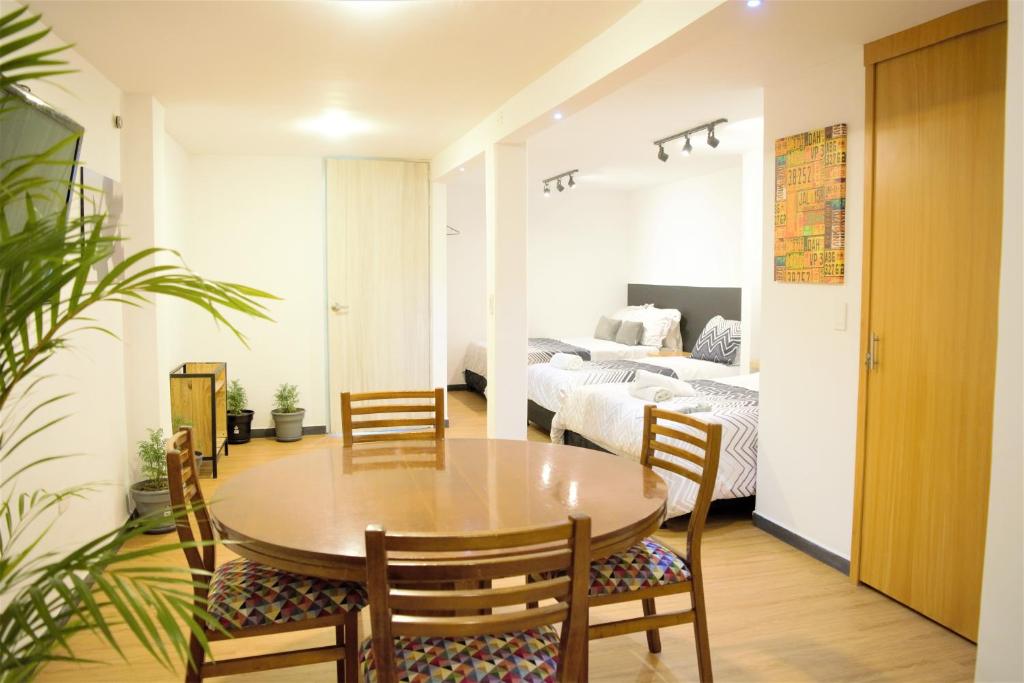 a dining room with a table and chairs and a bedroom at Casa Orquídea in Fusagasuga