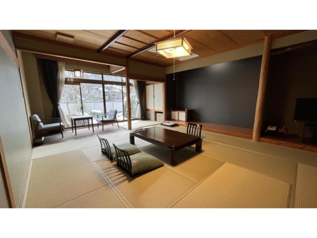a living room with a table and chairs at Tsukioka Onsen Furinya - Vacation STAY 55972v in Shibata