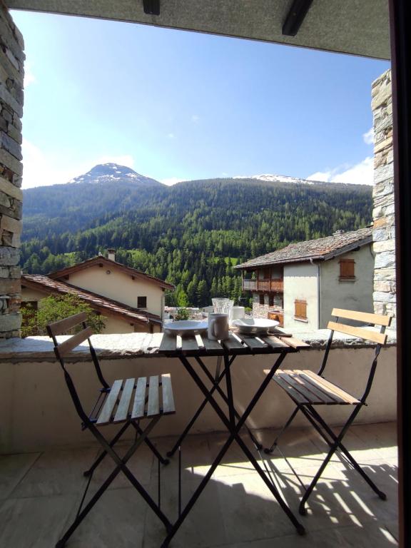 a table and chairs on a balcony with a view at Grand Studio Val Cenis in Lanslebourg-Mont-Cenis