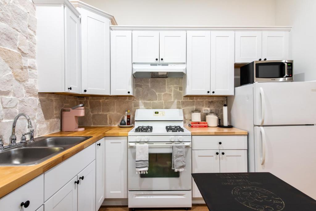 a kitchen with white cabinets and a white stove top oven at Derby City Urban Oasis in Louisville