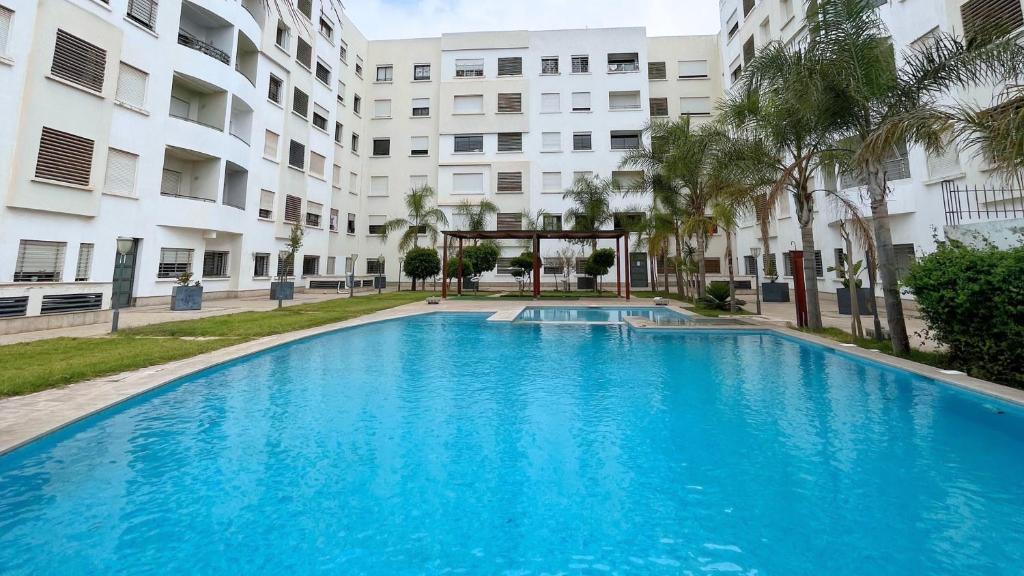 a large blue swimming pool in front of a building at Nouaceur Garden in Casablanca