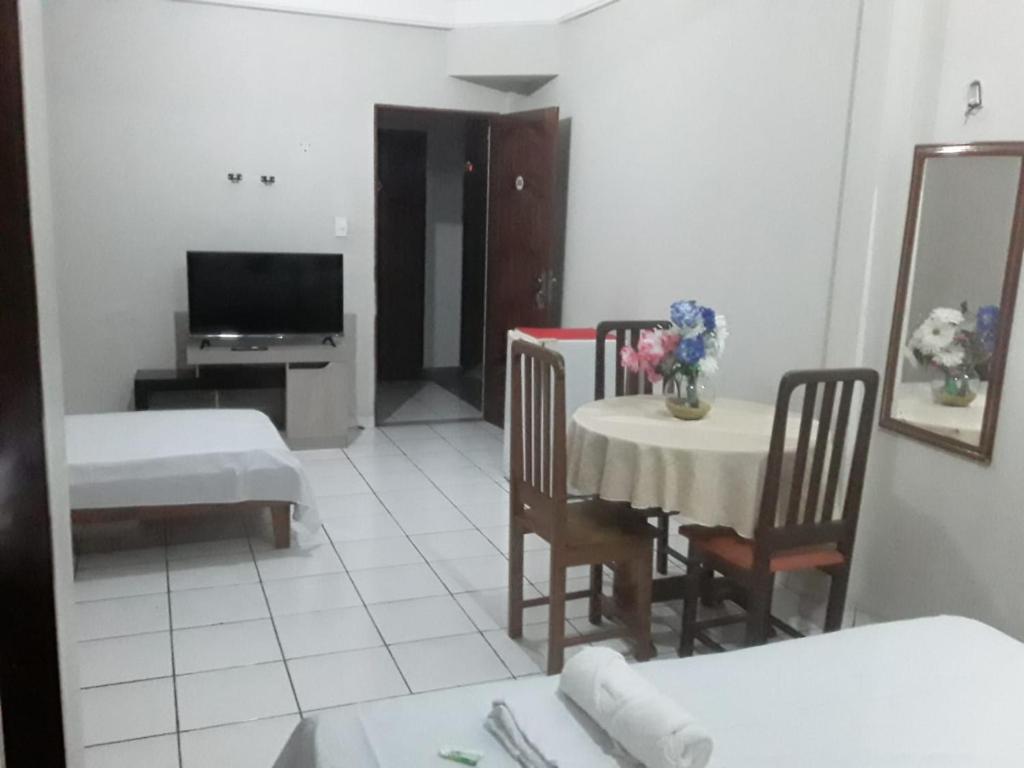 a living room with a table and chairs and a television at APARTHOTEL CENTRAL MACAPÁ in Macapá