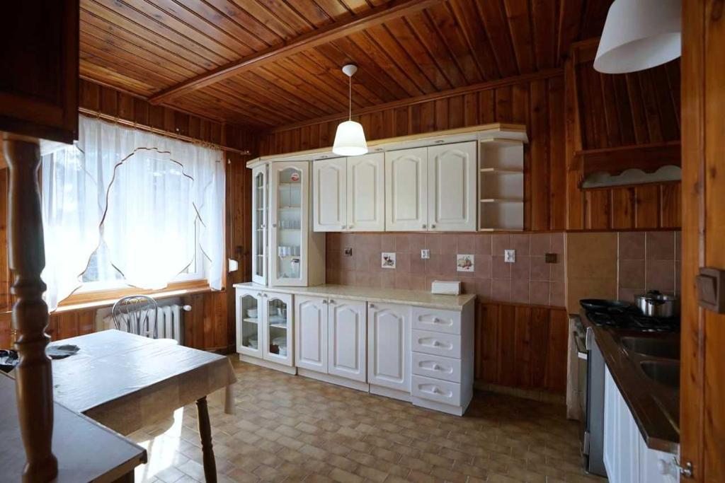 een keuken met witte kasten en een houten plafond bij Hostel na Anhellego in Szczecin
