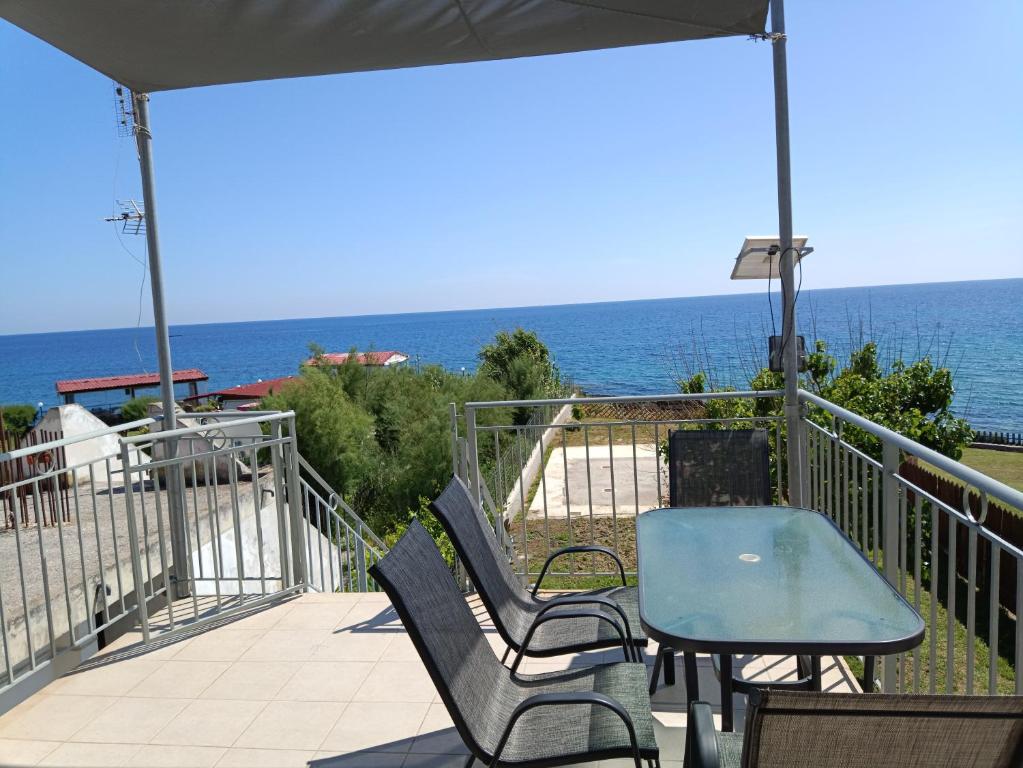 a patio with a table and chairs and the ocean at Apartment Batolios in Agios Georgios