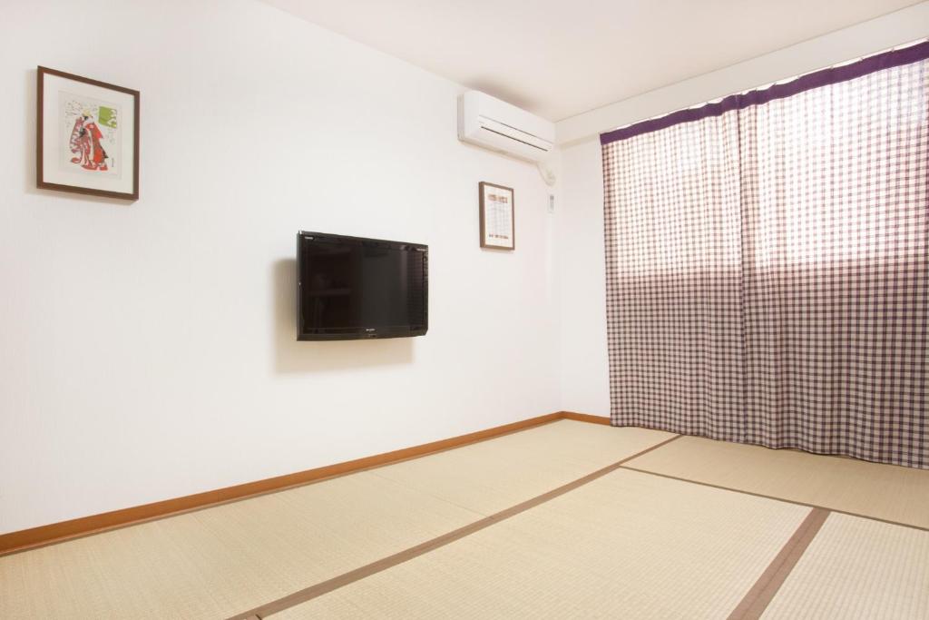 a room with a flat screen tv on a wall at Hotel Hanabi - Vacation STAY 62608v in Tokyo