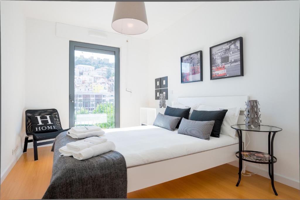 リスボンにあるFLH Martim Moniz Castle View Flatの白いソファと窓付きの白いベッドルーム1室
