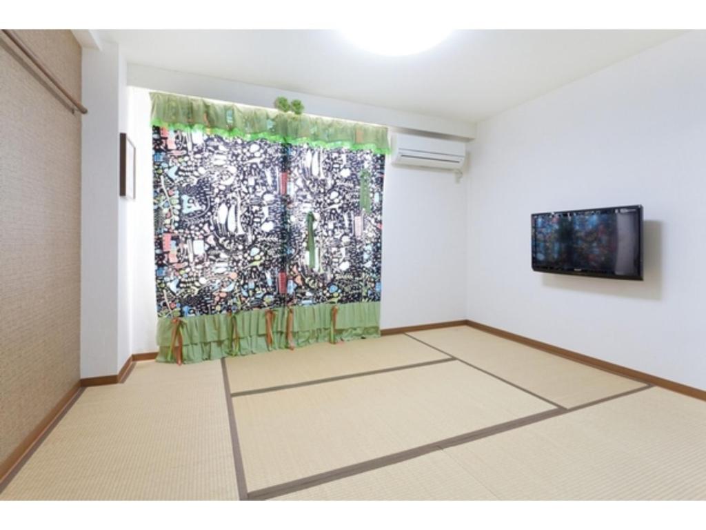 um quarto com uma pintura na parede e uma cortina em Hotel Hanabi - Vacation STAY 67110v em Tóquio
