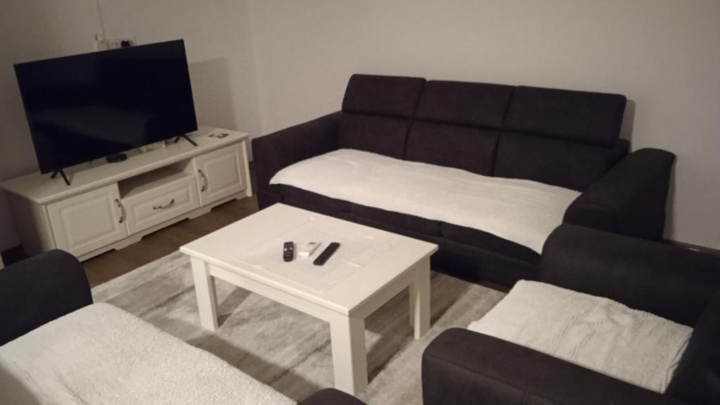 Una sala de estar con un sofá y un televisor. en MD1, en Trebinje