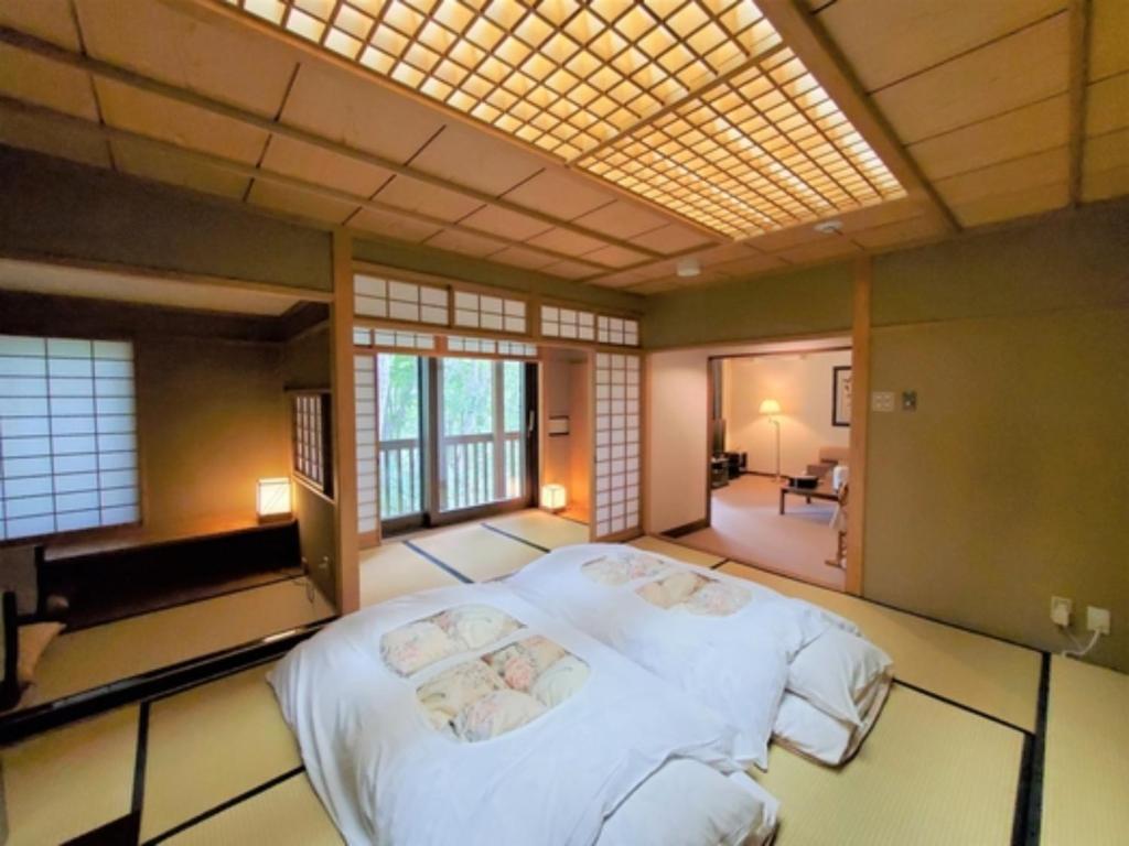青森市にあるSukayu Onsen Hakkoda Hotel - Vacation STAY 66848vのベッドルーム1室(白い大型ベッド1台付)