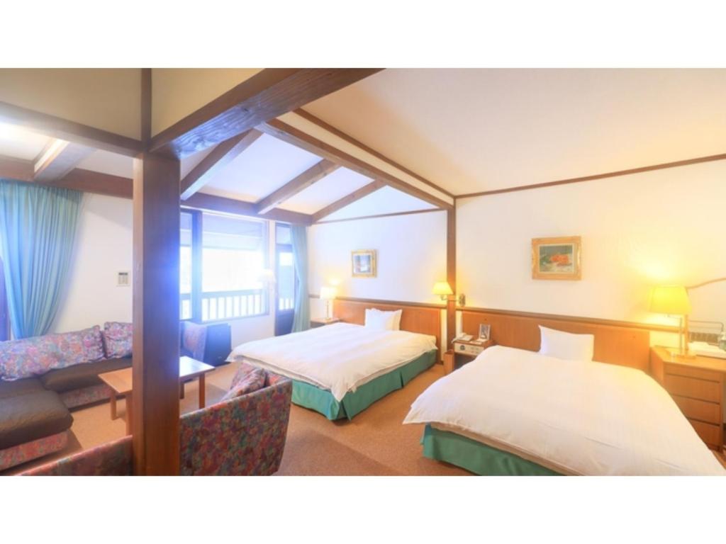a hotel room with two beds and a couch at Sukayu Onsen Hakkoda Hotel - Vacation STAY 66845v in Aomori