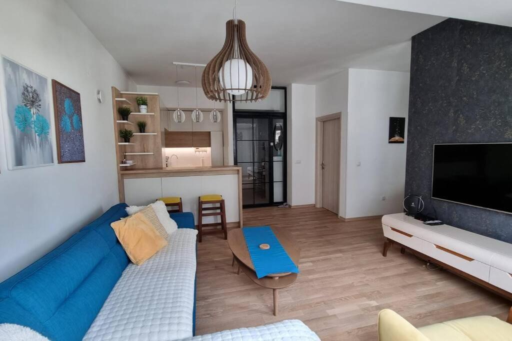 ein Wohnzimmer mit einem blauen Sofa und einer Küche in der Unterkunft The Urban Utopia in Skopje