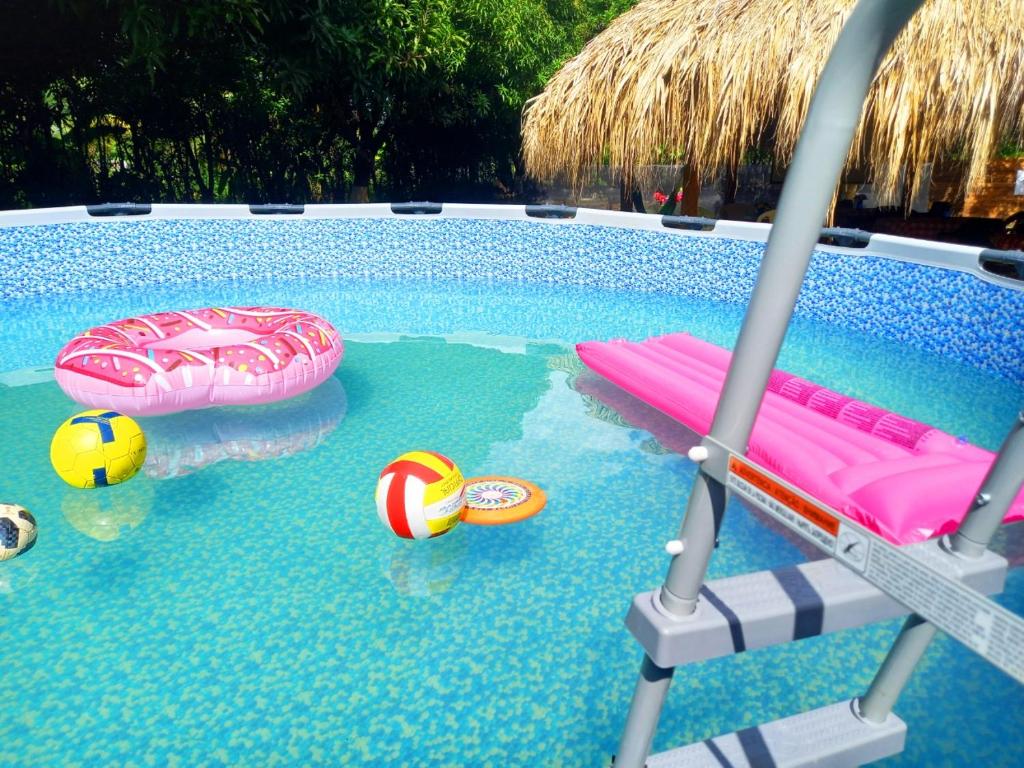 - une piscine avec 2 chaises et un terrain de volley dans l'établissement Cabañas Los Venaos, à San Bernardo del Viento