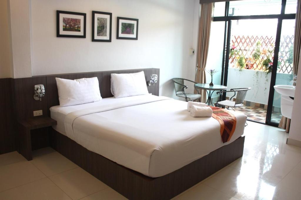 um quarto com uma cama grande e uma janela grande em P-Residence em Hat Yai