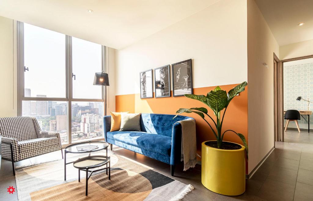 a living room with a blue couch and a potted plant at Casa Latitud by Kukun in Mexico City