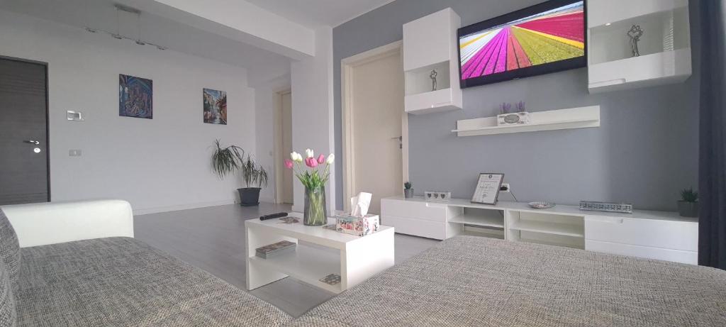 a living room with a bed and a tv on the wall at Stefania Sweet Apartament in Oradea
