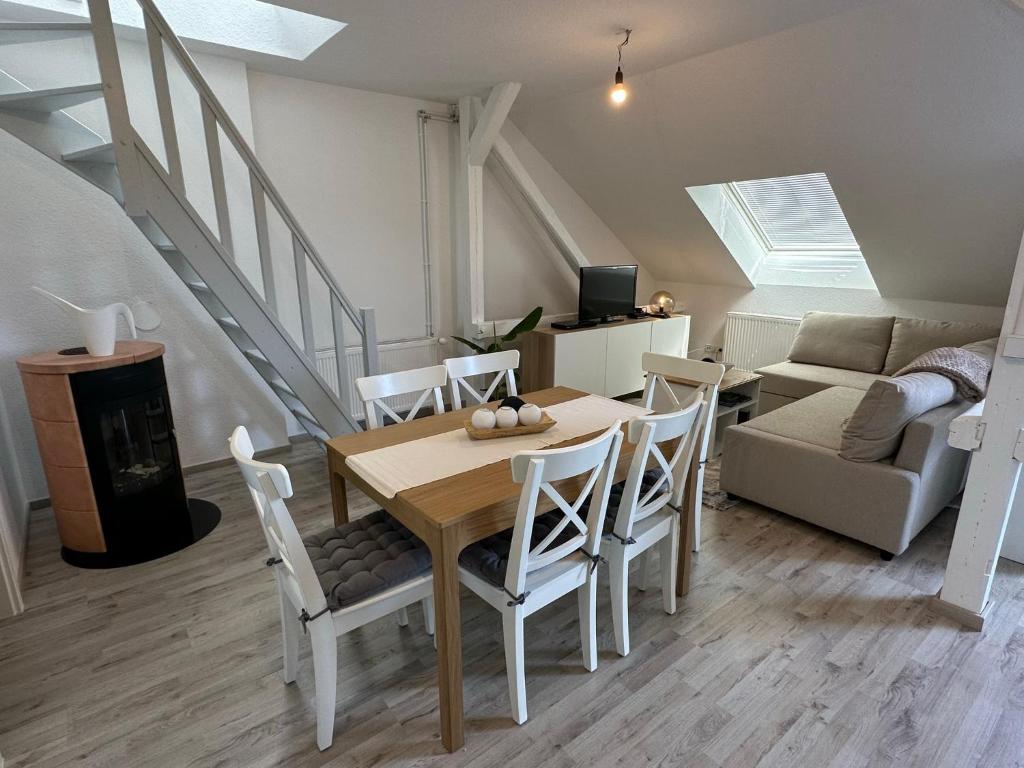 comedor y sala de estar con mesa y sillas en Gemütliche neurenovierte Dachgeschosswohnung, en Erfurt