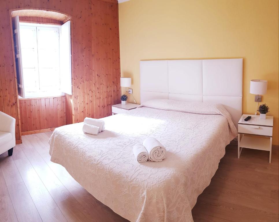 a bedroom with a large bed with towels on it at Alcamim Guesthouse in Elvas