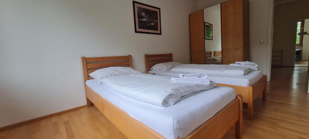 two beds in a room with white sheets at Four Seasons Getaway - 3 minutes From Town Centre in Zell am See