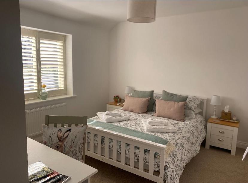 a bedroom with a bed and a table and a window at Burwood House 