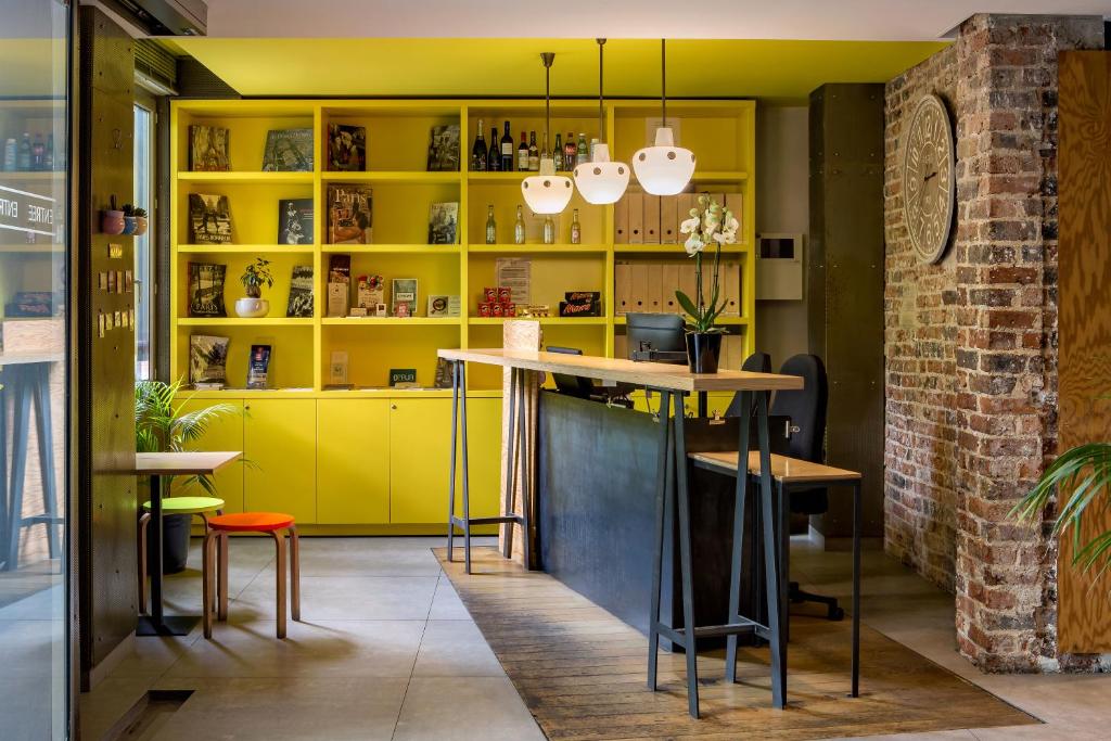 パリにあるオテル ガストンの黄色のキャビネットとテーブル付きのキッチン