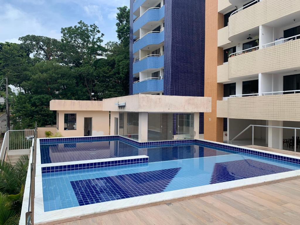 an empty swimming pool in front of a building at Apt no Melhor local em Lauro de Freitas in Lauro de Freitas