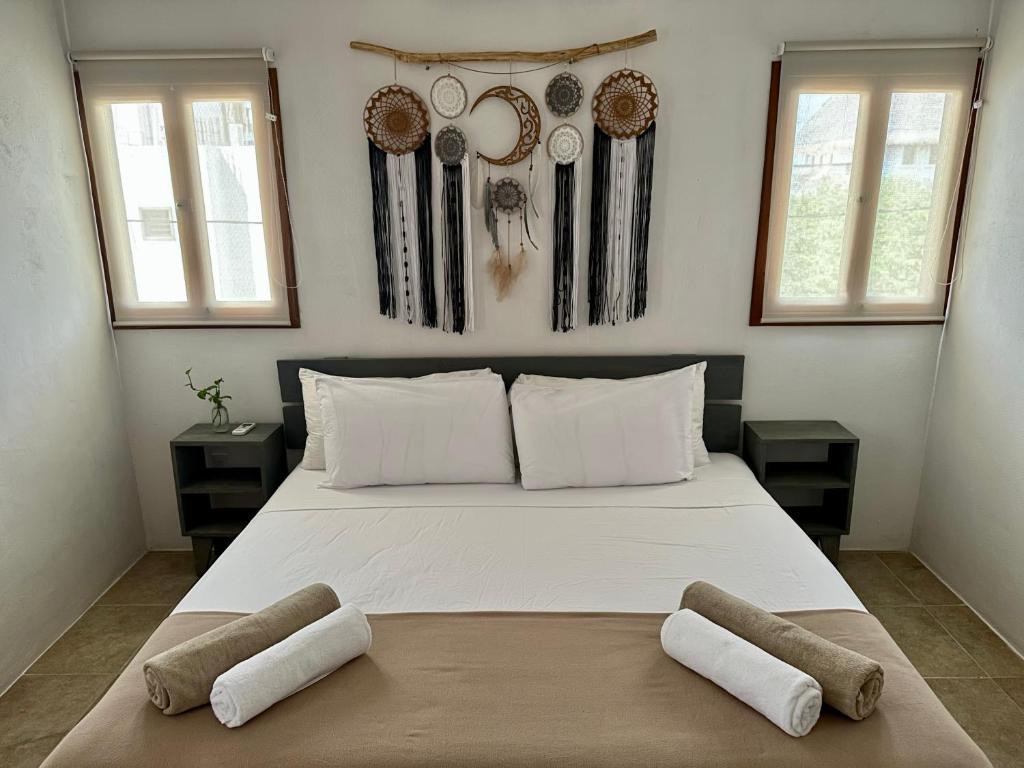 een slaapkamer met een groot wit bed met 2 kussens bij La Casa del Sol Holbox in Holbox Island