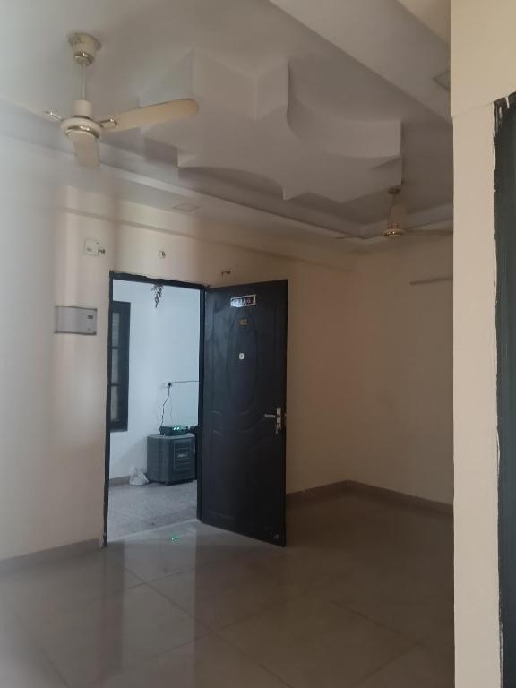 een lege kamer met een zwarte deur en een spiegel bij Sonia property in Rishīkesh