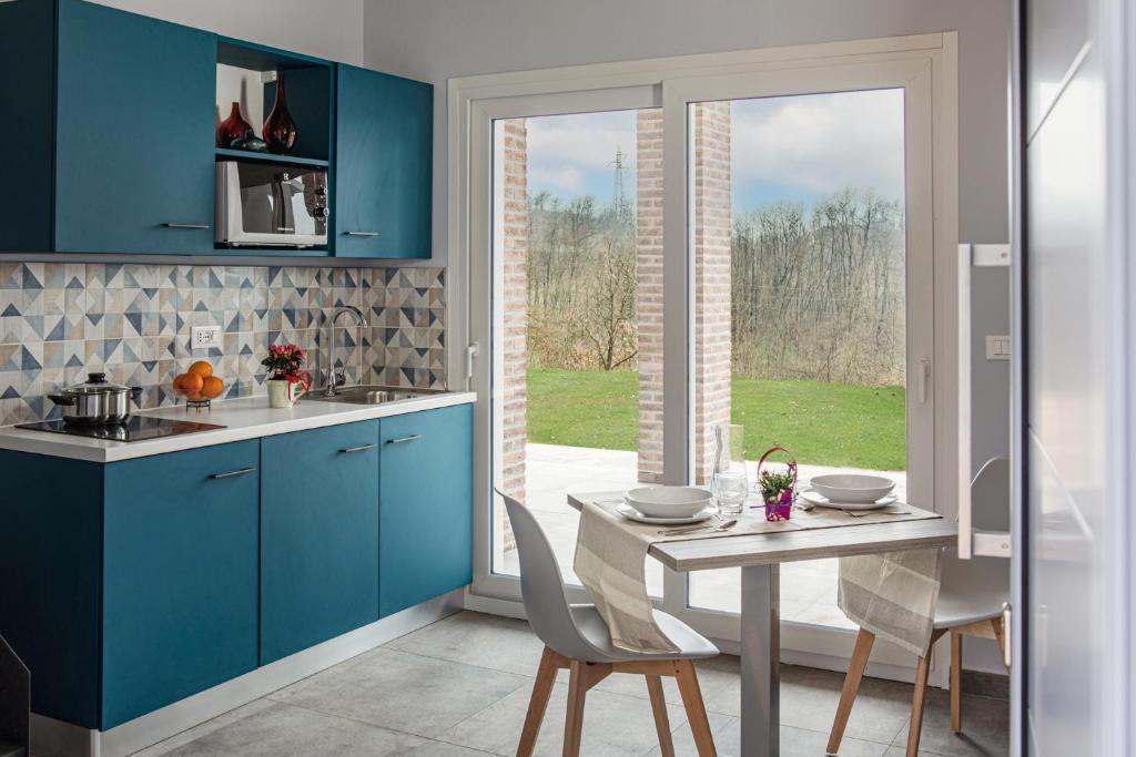 卡伊羅蒙泰諾泰的住宿－Ca' Brichella，厨房配有蓝色橱柜和桌椅
