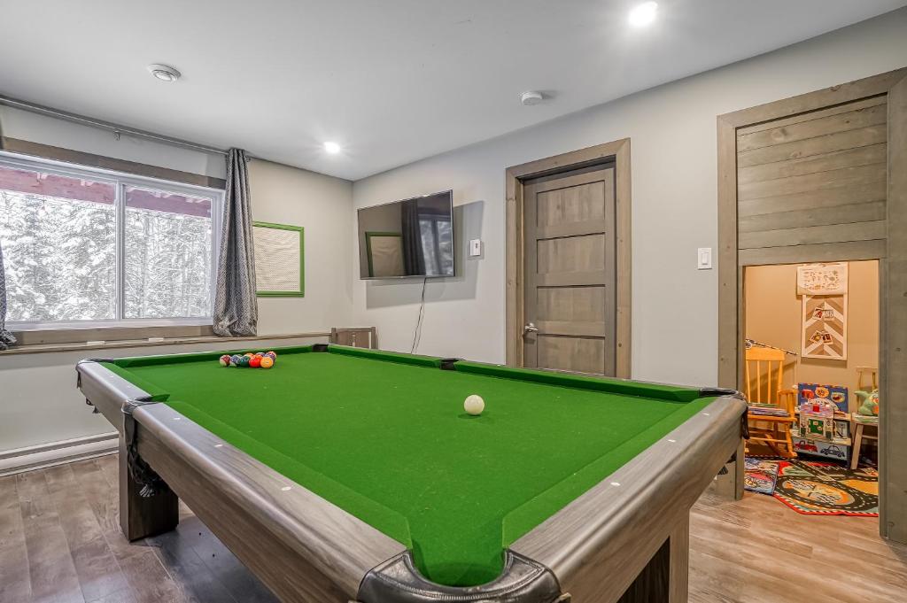 a pool table in a living room with afits at Condo familiale Billard et spa, 350m de la montagne de ski in Mont-Blanc