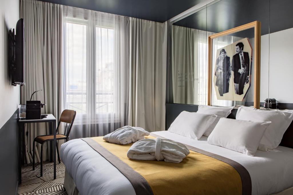 a hotel room with a large bed and a window at Hôtel Gaston in Paris