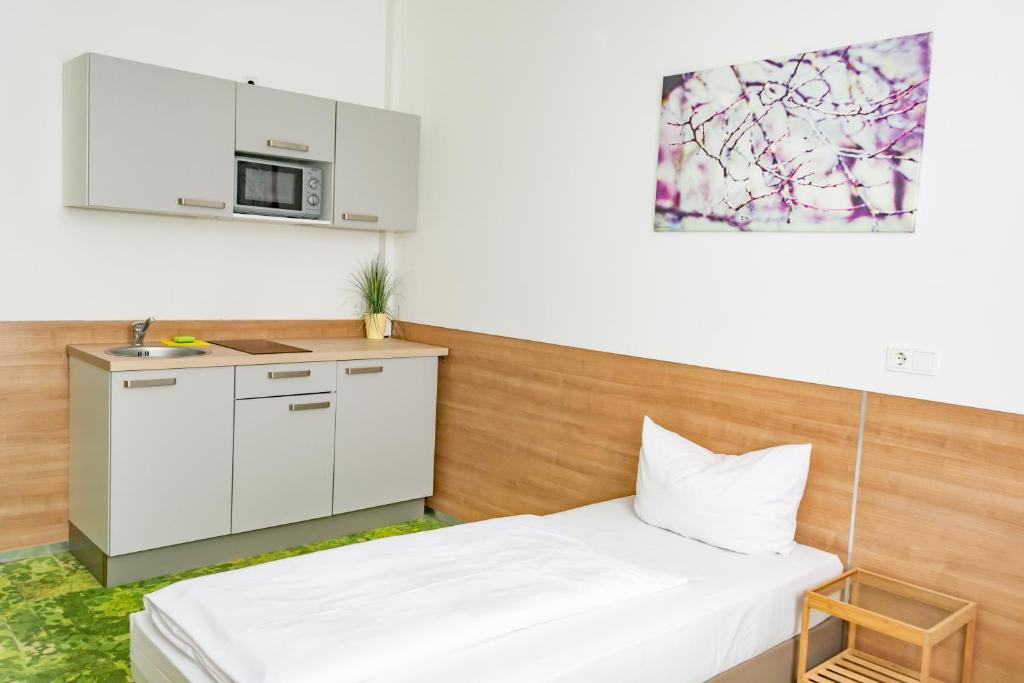 Habitación pequeña con 2 camas y cocina en 24seven Apartments - Self Check-IN, en Landshut