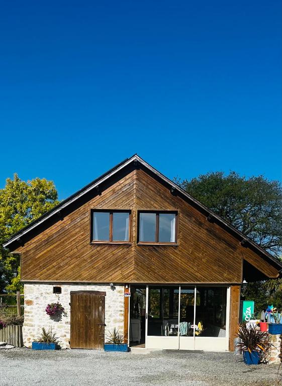 - un grand bâtiment en bois avec des fenêtres dans l'établissement Maison de campagne, à Montsûrs