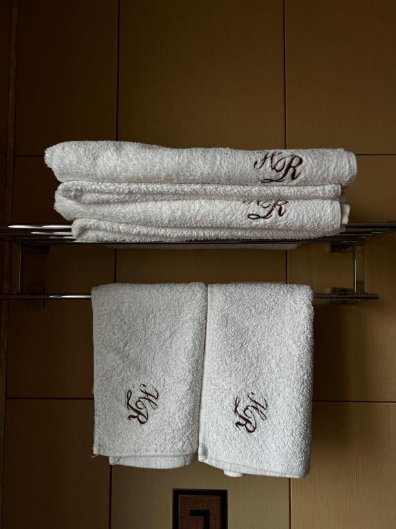 eine Gruppe Handtücher auf einem Regal im Bad in der Unterkunft Hotel Rion in Mangalia
